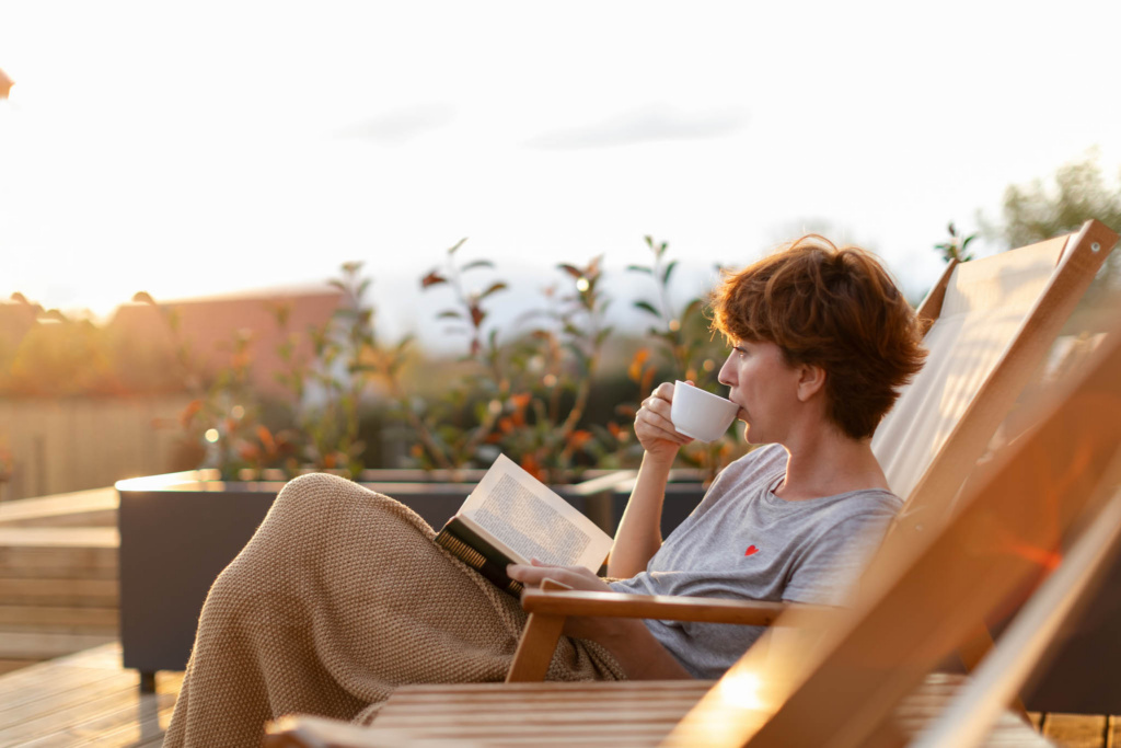 woman-enjoying-coffee-on-patio-reading-book